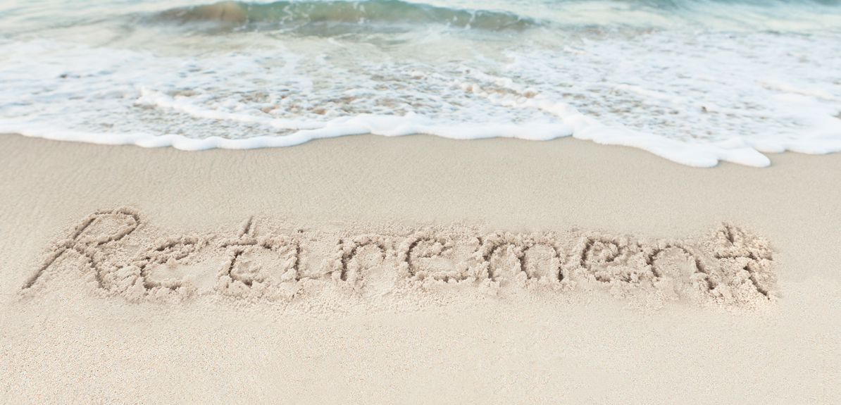 "Retirement" written in the sand at the beach.