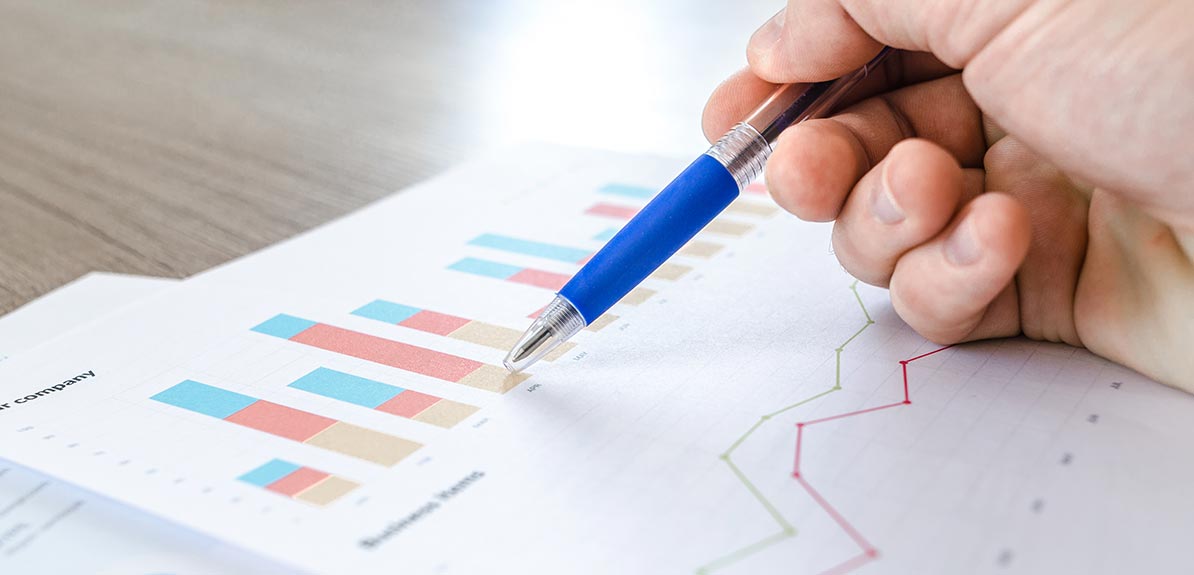 Image of someone reading graphs on a piece of paper.